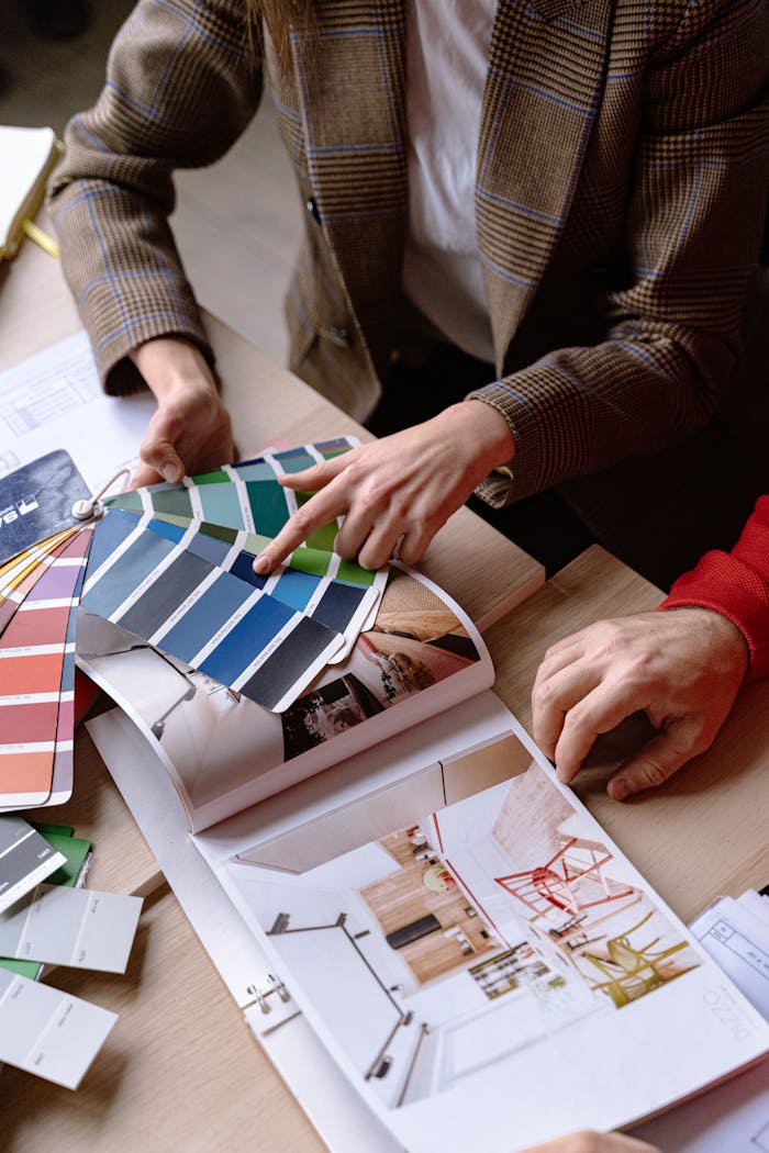 services-02 Interior designers discuss color swatches and design ideas at a table, planning a creative project.